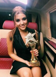 Hande Erçel posing with her Best Actress Award for the television show Güneşin Kızları